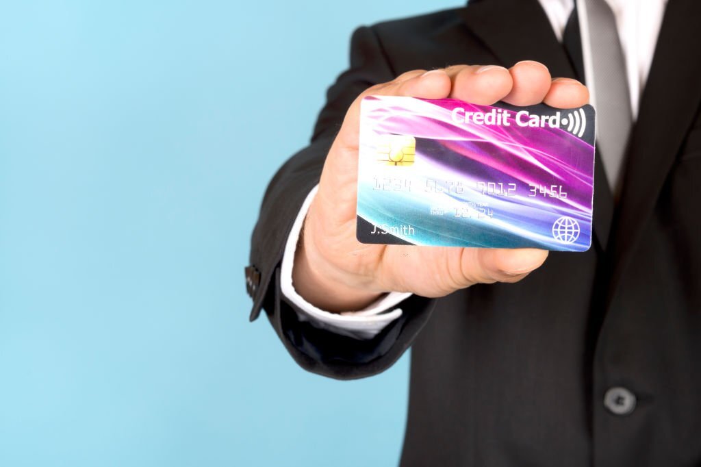 Business man holding a contactless credit card.